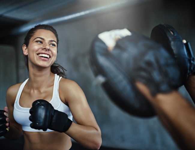 Shot of a young woman sparring with a boxing partner at the gym